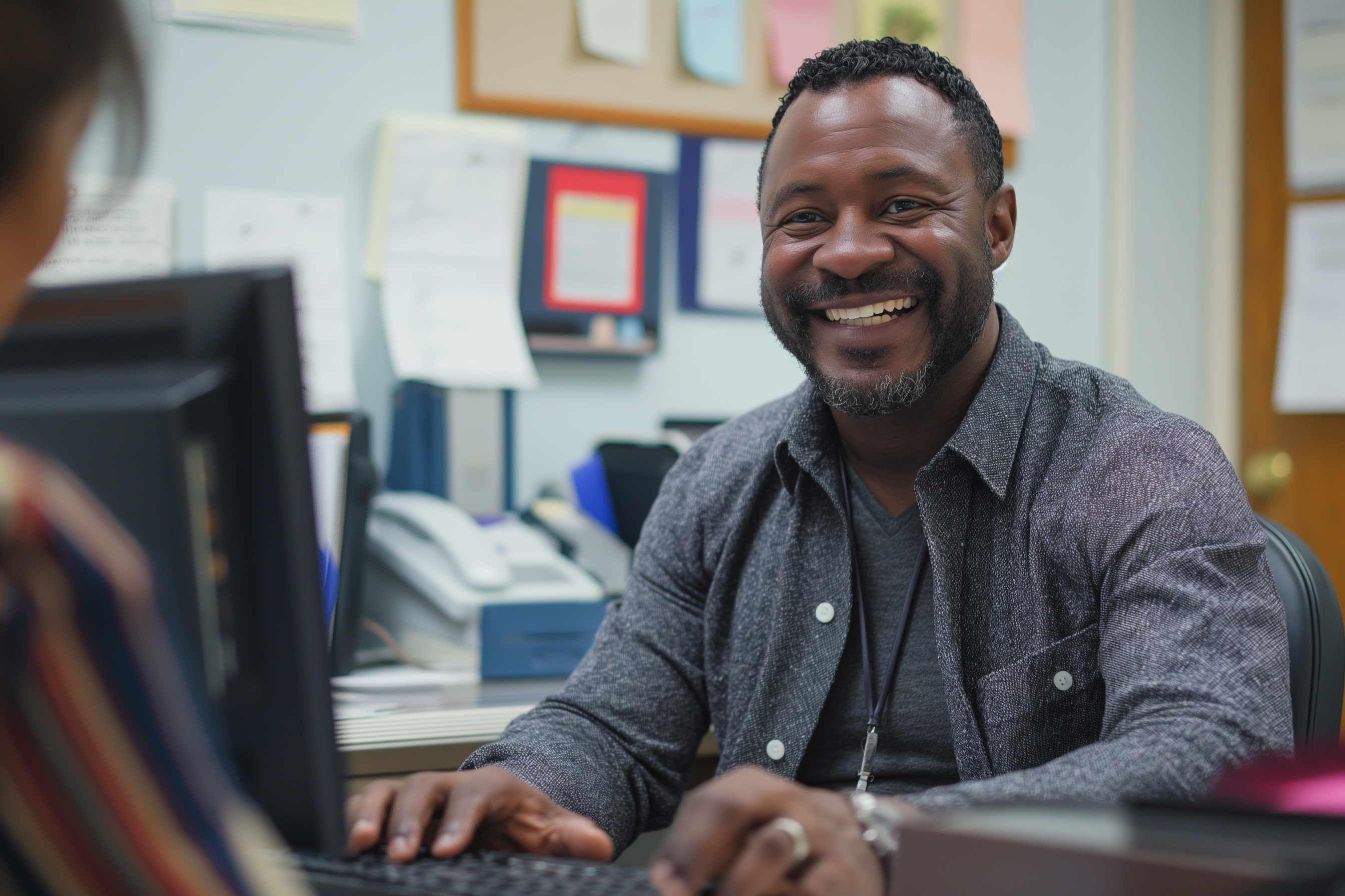 Smiling man typing at office computer