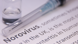 Syringe and vial on norovirus article