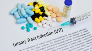 Pills, syringe, and vial on UTI document