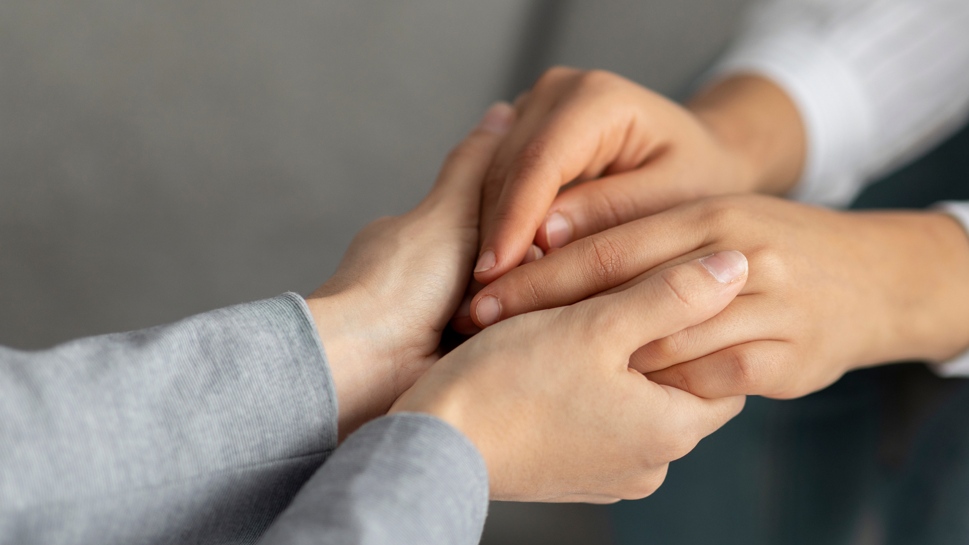 Two people holding hands in a supportive and comforting manner.