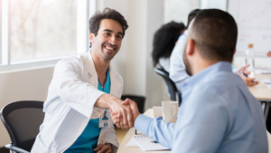 Smiling doctor shaking hands with patient