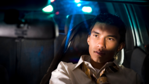 Man in car under blue flashing lights