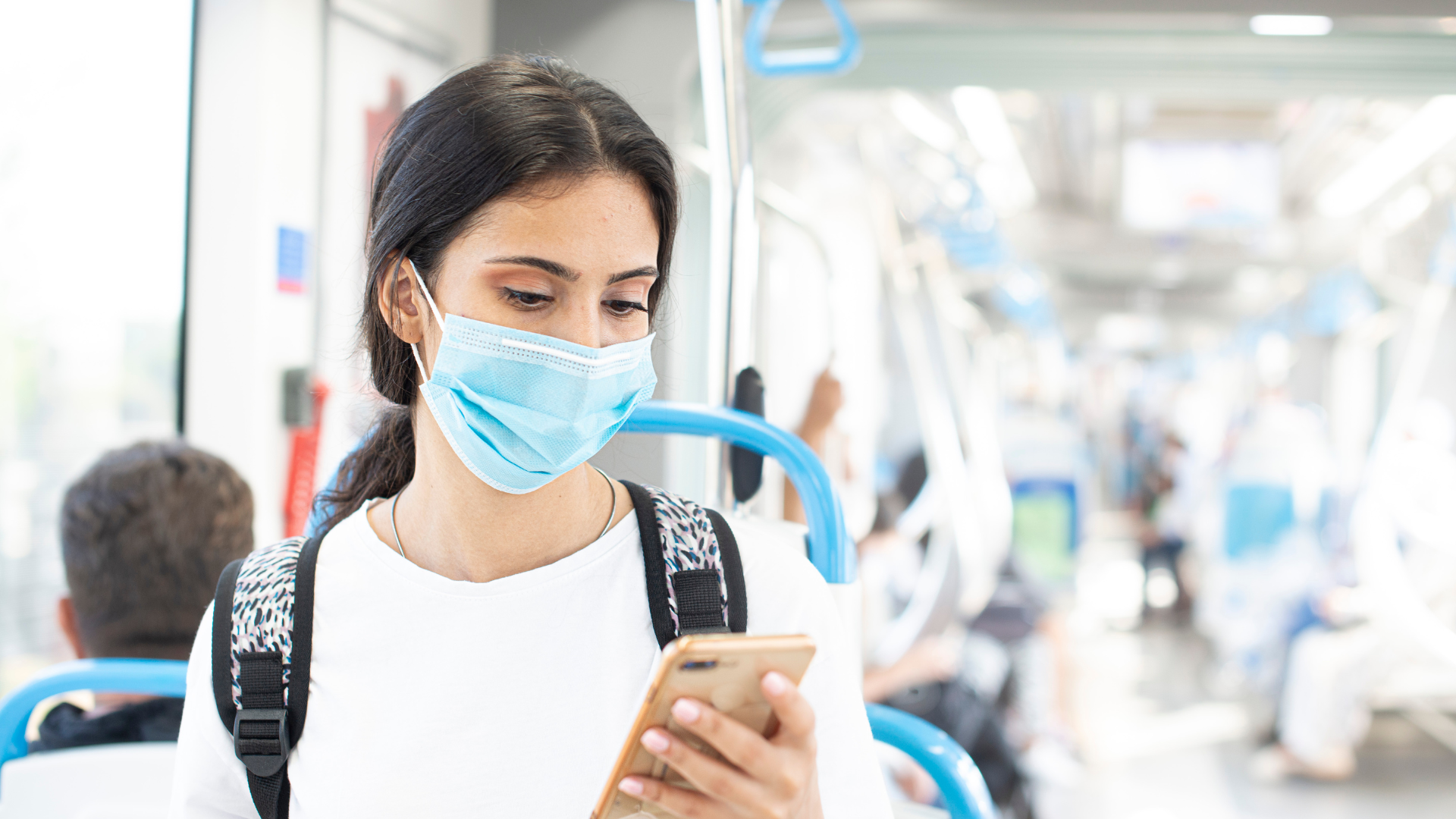 Woman on the bus wearing a face mask, on cellphone, protecting from infectious disease, COVID-19.