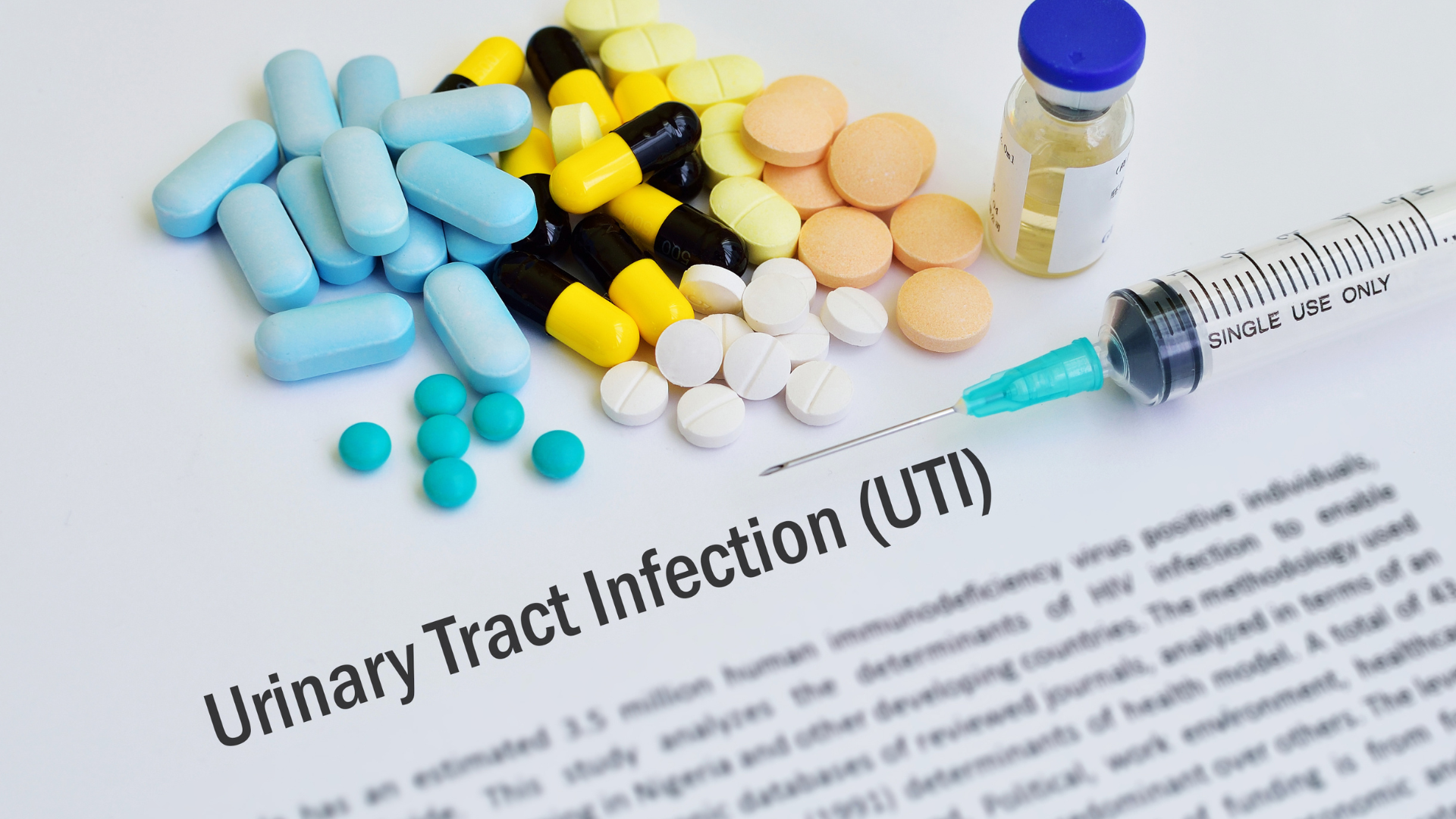 A report with the title "Urinary Tract Infection (UTI)", above it there is a needled syringe, a vial of medicine, and a variety of pills and capsules.